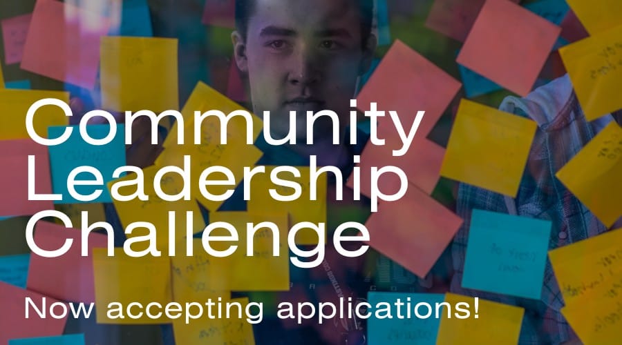 Wall with stickies covering it and words Community Leadership Challenge.