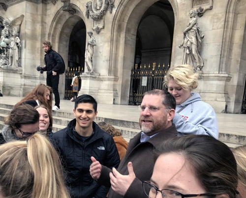 Group of students on steps in front of Paris Opera house.