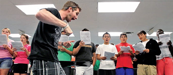Jeff Vyhlidal ' 08 leads a singing rehearsal during a camp at Grand Island (Neb.) Senior High School. Photo By: Crystal LoGiudice/G.I. Independent jeff v 2014